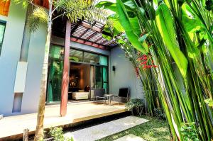 a house with a porch with palm trees at Villa Casablanca in Ban Saiyuan (1)