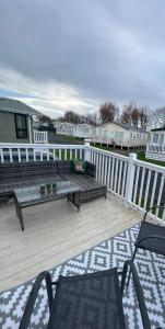 a deck with a couch and chairs on a porch at Sun sea and sand at Whitley bay in Hartley