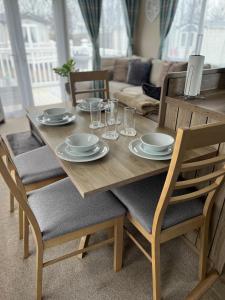 a dining room table with plates and glasses on it at Sun sea and sand at Whitley bay in Hartley