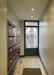 um corredor com uma porta e uma janela num quarto em Charmant appartement 1930 Centre-ville Nogent-sur-Marne em Nogent-sur-Marne