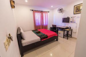 Dormitorio con cama, escritorio y TV en CENTRAL BACKPACKER en Siem Riep