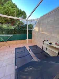 un patio cubierto con mesa y banco en Apartamento con terraza en San Juan Playa, en Alicante