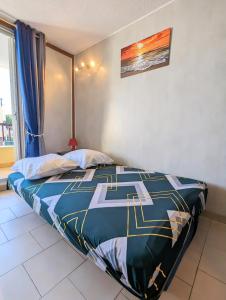 sypialnia z łóżkiem z niebieską kołdrą w obiekcie Appartement au CALME + parking w Cap d'Agde