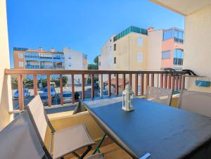 a blue table and chairs on a balcony at Appartement au CALME + parking in Cap d'Agde