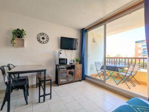 salon ze stołem i telewizorem w obiekcie Appartement au CALME + parking w Cap d'Agde