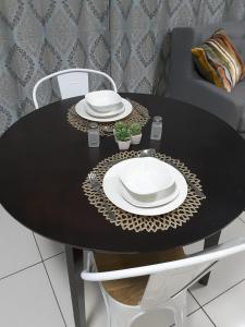 a black table with two white plates on it at City View Unit 130 at 77 on Independence in Windhoek