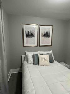 a bedroom with a white bed with two pictures on the wall at Harris Home in Birmingham