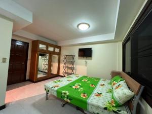 a bedroom with a bed and a flat screen tv at Hideaway House Patong in Patong Beach