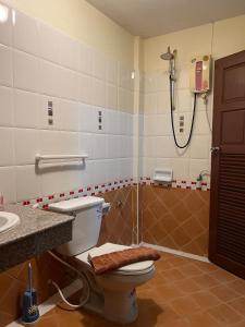 a bathroom with a shower and a toilet and a sink at Hideaway House Patong in Patong Beach