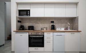a kitchen with white cabinets and a microwave at Free parking Basilica Leo's home - AC, Wi-Fi, smart TV in Budapest