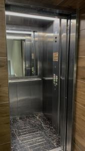 a metal elevator with a glass door in a building at Hotel Sofia in Polyana