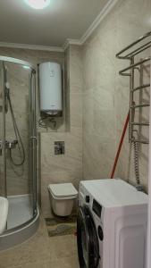 a bathroom with a shower toilet and a washing machine at Hotel Sofia in Polyana