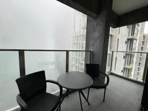 a table and chairs on a balcony with a table at The Minnook Suites, Genting Highlands in Genting Highlands