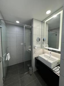 ein Bad mit einem Waschbecken und einem Spiegel in der Unterkunft The Minnook Suites, Genting Highlands in Genting Highlands