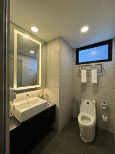 ein Badezimmer mit einem WC, einem Waschbecken und einem Spiegel in der Unterkunft The Minnook Suites, Genting Highlands in Genting Highlands