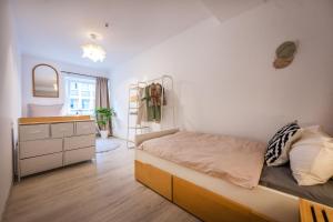 um pequeno quarto com uma cama e uma cómoda em 140qm 3BR apartment - central, cozy and stylish em Koblenz