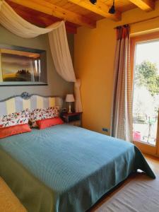 una camera con un grande letto e una finestra di VILLA DEI TRAMONTI a Gavirate