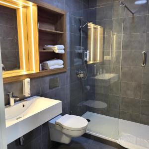 een badkamer met een douche, een toilet en een wastafel bij Hotel Centrum in Bolesławiec