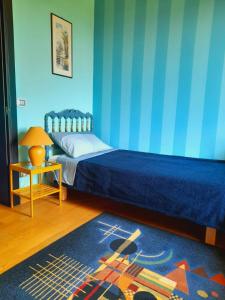 una camera con un letto con una parete blu di VILLA DEI TRAMONTI a Gavirate