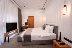 Un dormitorio con cama, escritorio y televisión. en Revive Boutique Hotel, en Ereván