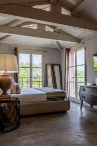 a bedroom with a bed and a large window at La Bastide Du Clos des Roses - Teritoria in Fréjus