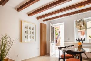 a dining room with white walls and wooden beams at Villa Lemonia in Rethymno Town
