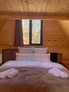 1 dormitorio con 1 cama grande y 2 almohadas en Twin cottages kazbegi 2 en Kazbegi