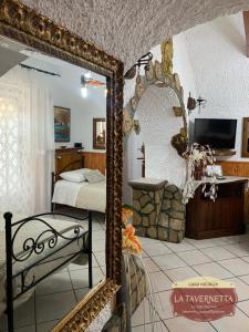 einen Spiegel in einem Schlafzimmer mit einem Bett und einem TV in der Unterkunft La Tavernetta in Pignola