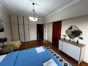 a bedroom with a blue bed and a mirror at Kouros City Center in Kavala