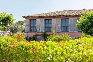 an old house with flowers in front of it at La Bastide Du Clos des Roses - Teritoria in Fréjus