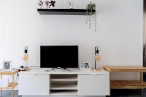 un soggiorno con TV su una scrivania bianca di Apartamentos Entreteatros, fantástico duplex casco histórico a Talavera de la Reina
