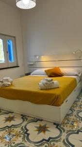 una camera da letto con un letto e asciugamani di Luxury apartments Caucich a Città di Lipari