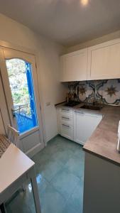una cucina con armadi bianchi e una grande finestra di Luxury apartments Caucich a Città di Lipari