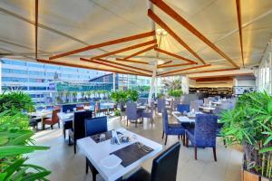 un restaurante con mesas, sillas azules y registrador en Iris The Business Hotel en Bangalore