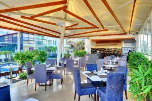 a restaurant with blue chairs and tables and tablesktop at Iris The Business Hotel in Bangalore