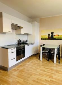 een keuken met witte kasten en een tafel met een eetkamer bij After Six Apartment in Bratislava