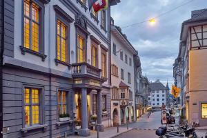 eine Stadtstraße mit vielen Gebäuden und einem Motorrad auf der Straße in der Unterkunft Sorell Hotel Rüden in Schaffhausen