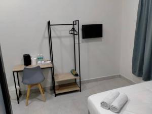 a bedroom with a desk and a bed and a chair at Hotel Mutiara Kuala Krai in Kuala Kerai