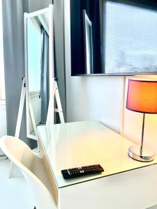 une télécommande sur une table avec une lampe sur celle-ci dans l'établissement Huttunen - Ihqu kolmio loistavalla sijainnilla, à Iisalmi