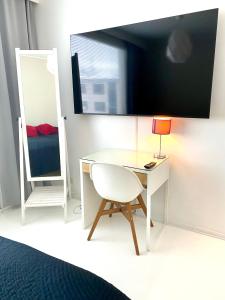 Cette chambre comprend un bureau, une chaise et un miroir. dans l'établissement Huttunen - Ihqu kolmio loistavalla sijainnilla, à Iisalmi