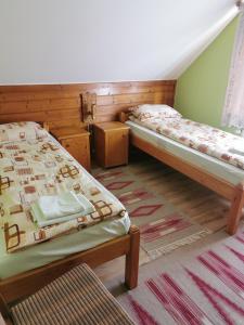 two twin beds in a room with at Emília vendégház in Ciumani