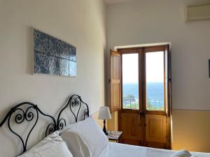 a bedroom with a bed with a view of the ocean at Hotel La Locanda Del Postino in Pollara