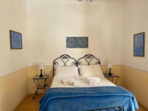 a bedroom with a bed with a blue blanket at Hotel La Locanda Del Postino in Pollara