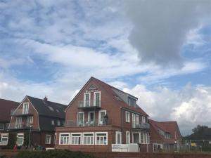 een groot bakstenen gebouw met een hemel op de achtergrond bij Haus Nordland in Juist