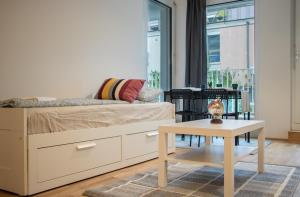 Schlafzimmer mit einem Bett, einem Tisch und einem Fenster in der Unterkunft Flat2go modern apartments - Harmony of city and nature in Wien