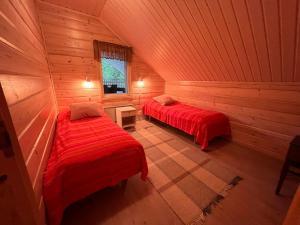 a room with two beds in a log cabin at Keskikosken Lomamökit in Venäjänjärvi