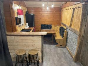 una cucina con bancone e sgabelli in una cabina di Le petit chalet du mouralet a Légna Altre 7 foto