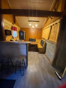a room with a bar and a desk in a trailer at Le petit chalet du mouralet in Légna
