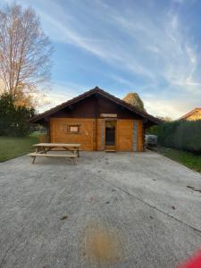 a log cabin with a picnic table in front of it at Le petit chalet du mouralet in Légna