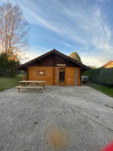 una baita di tronchi con un tavolo da picnic di fronte ad essa di Le petit chalet du mouralet a Légna